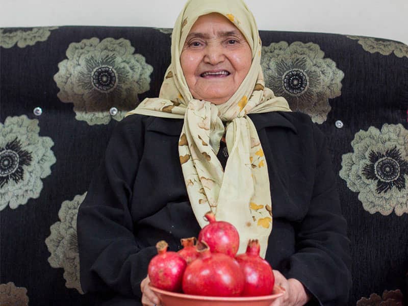 مادربزرگی که یک بشقاب انار دستش گرفته