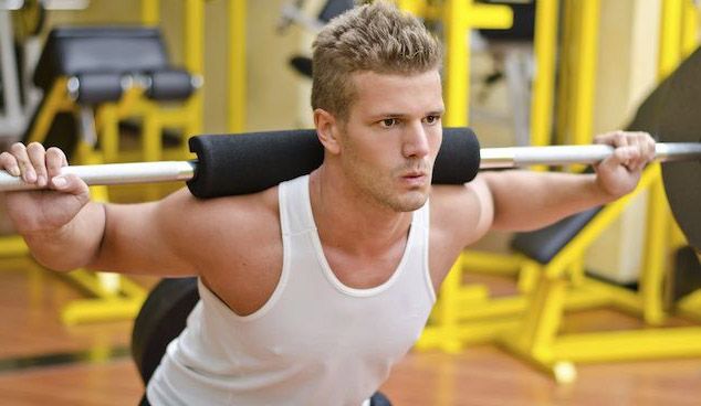 مرد خم شده در حال اسکات با وزنه - فیت شیپ